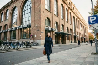 Façade extérieure du campus Station F à Paris 13e avec une jeune femme marchant sur le trottoir